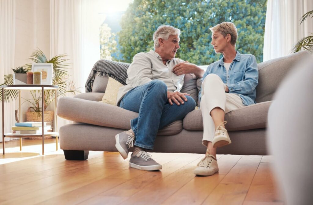 A senior couple sits on their couch in memory care, taking time to be intentional about how they talk to each other