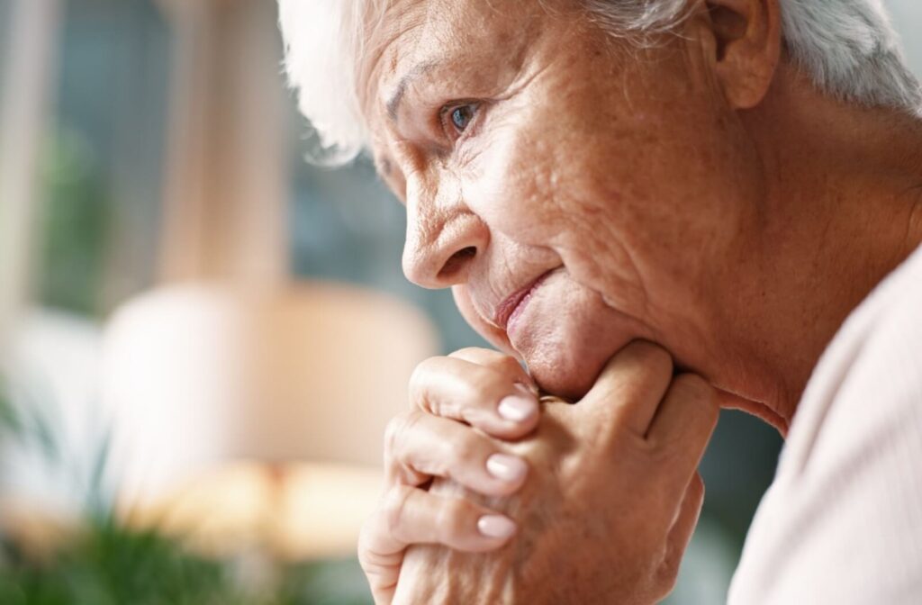 An unhappy senior with dementia is lonely at home.