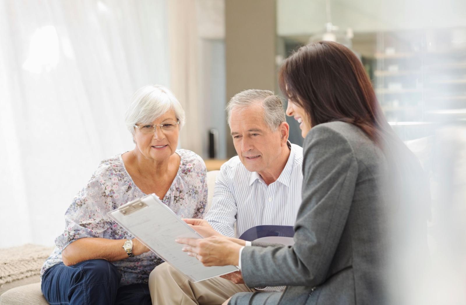 a senior living employee speaks to two seniors